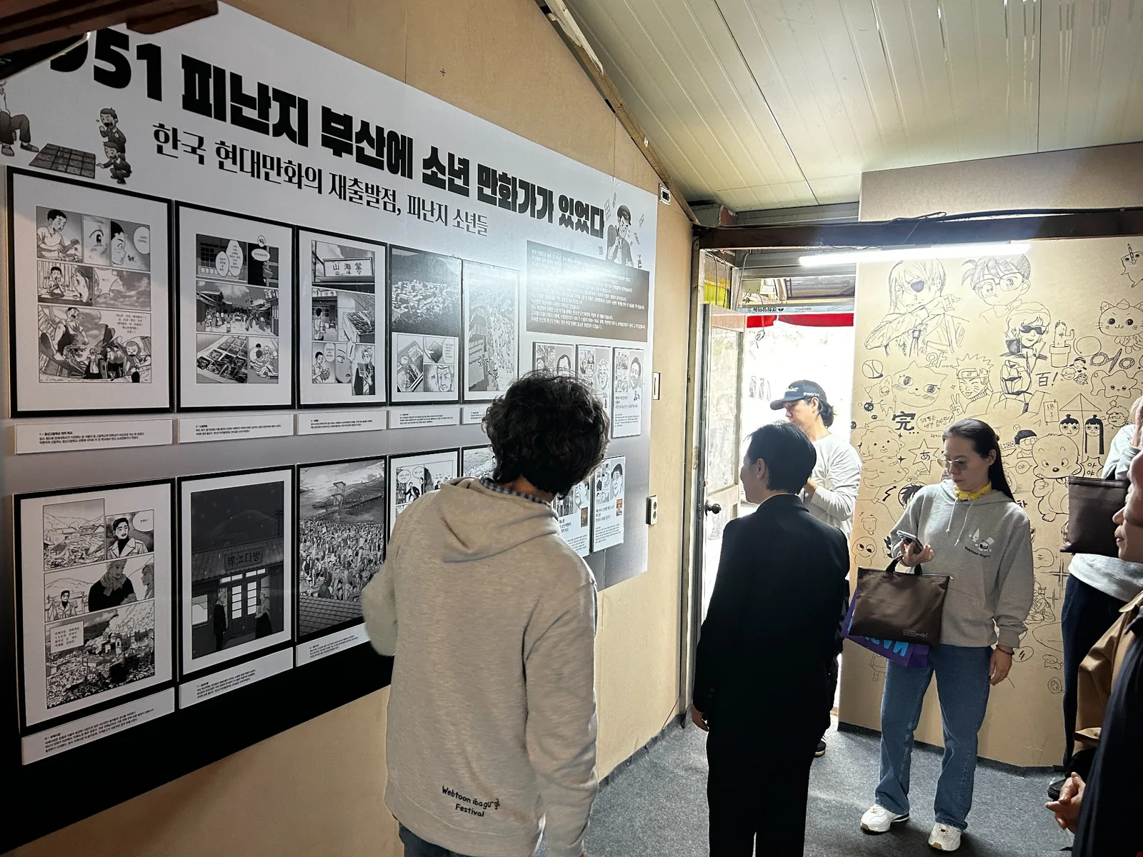 한국 현대만화 역사 전시를 관람하는 방문객